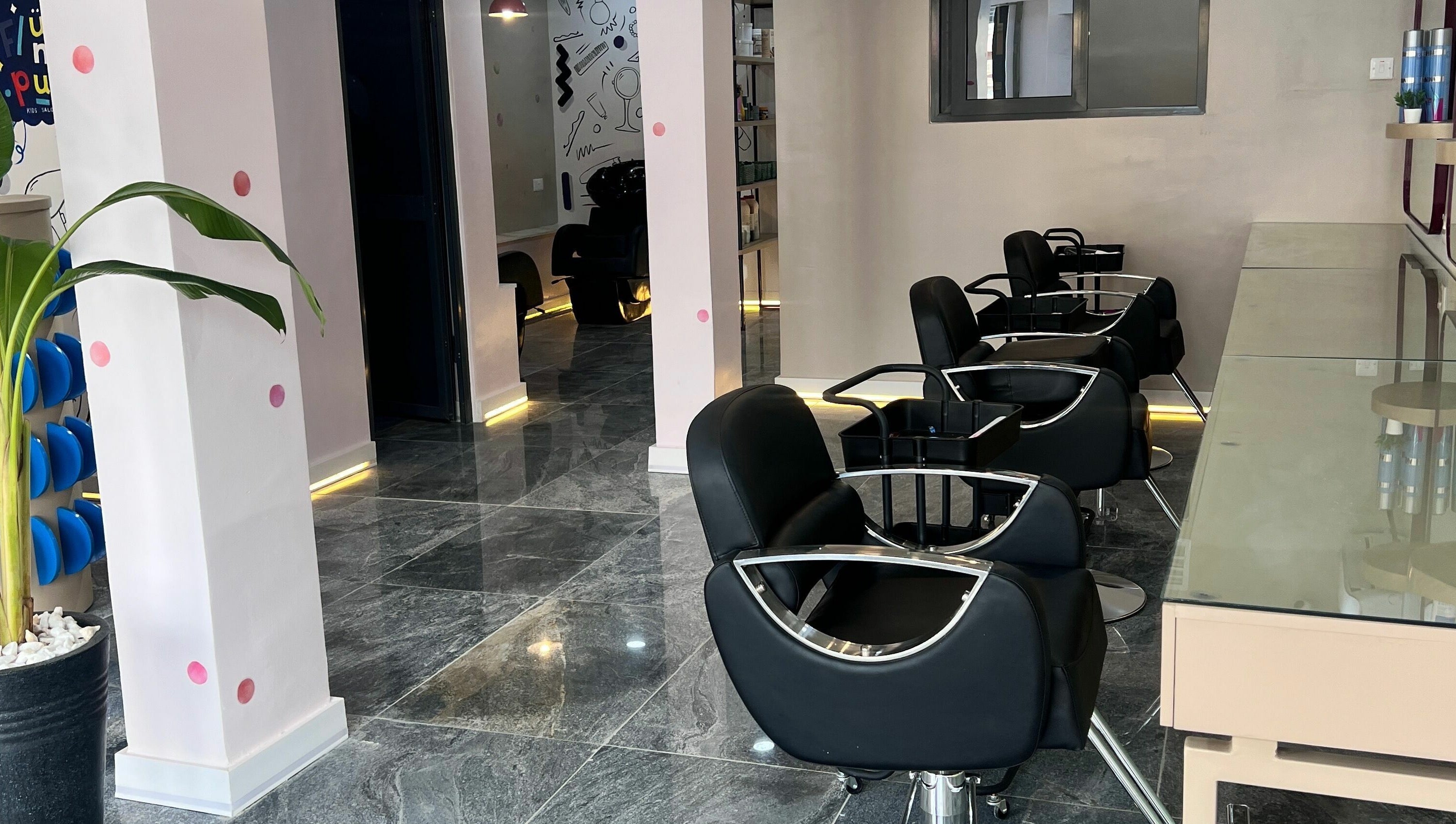 Stylish interior of Fluff n Puff salon with black chairs in Lekki, Lagos, NG.
