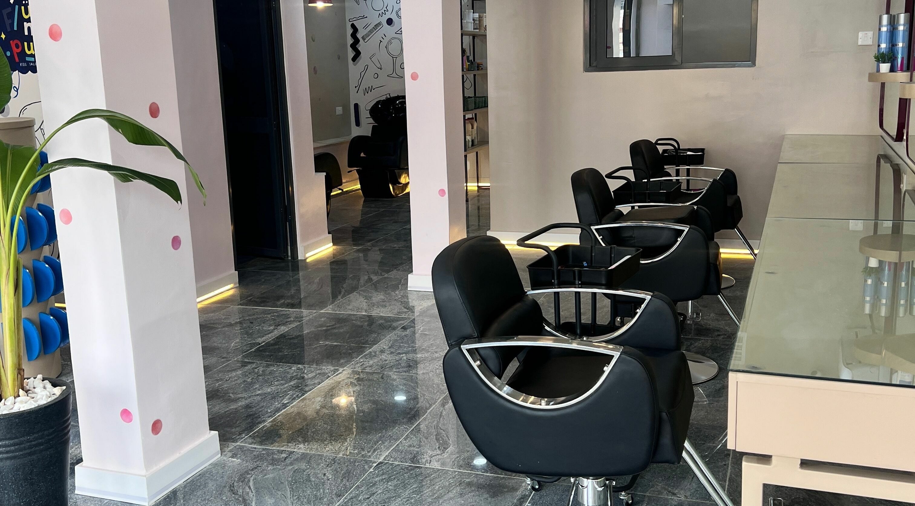 Stylish interior of Fluff n Puff salon with black chairs in Lekki, Lagos, NG.