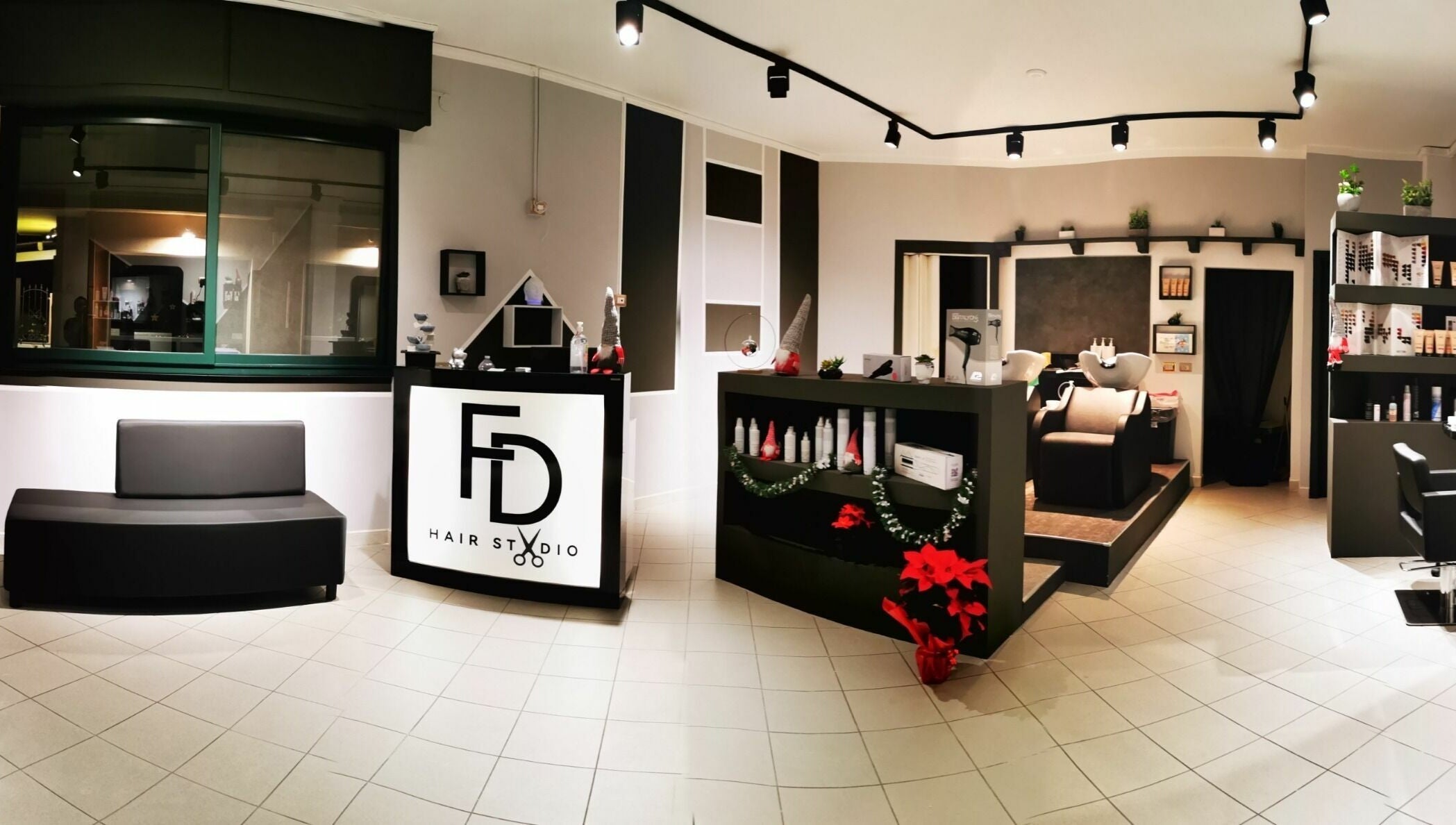 Interno moderno di FD Hair Studio a Quartucciu, Sardegna, IT, con arredi eleganti e postazione di lavaggio.