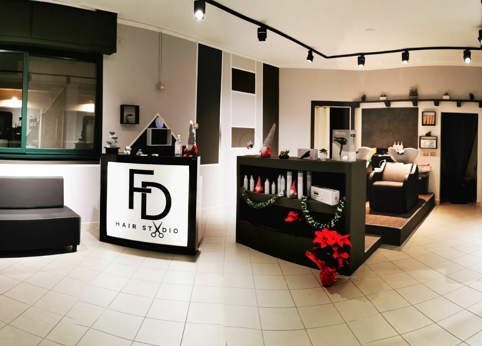 Interno moderno di FD Hair Studio a Quartucciu, Sardegna, IT, con arredi eleganti e postazione di lavaggio.