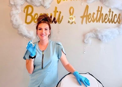 Aesthetician at H Derma Beauti Aesthetics Norwich in blue uniform, conducting beauty treatment in Norwich, England, GB.