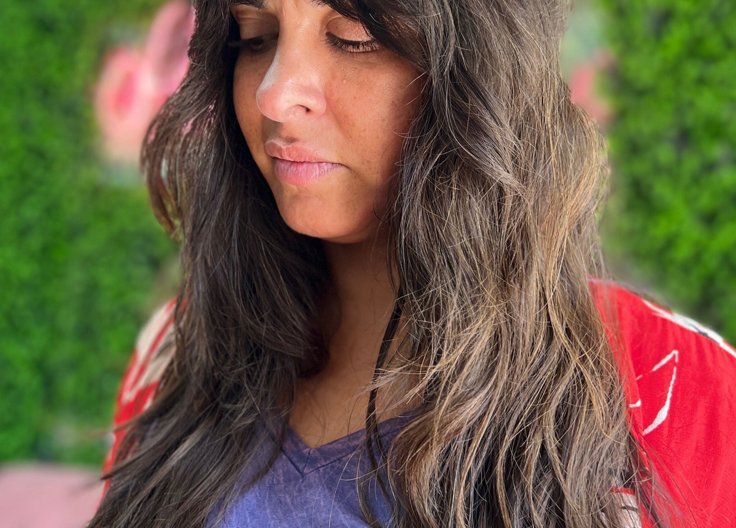 Mujer con cabello largo en What da Hair, Providencia, Región Metropolitana, CL, rodeada de un fondo verde.