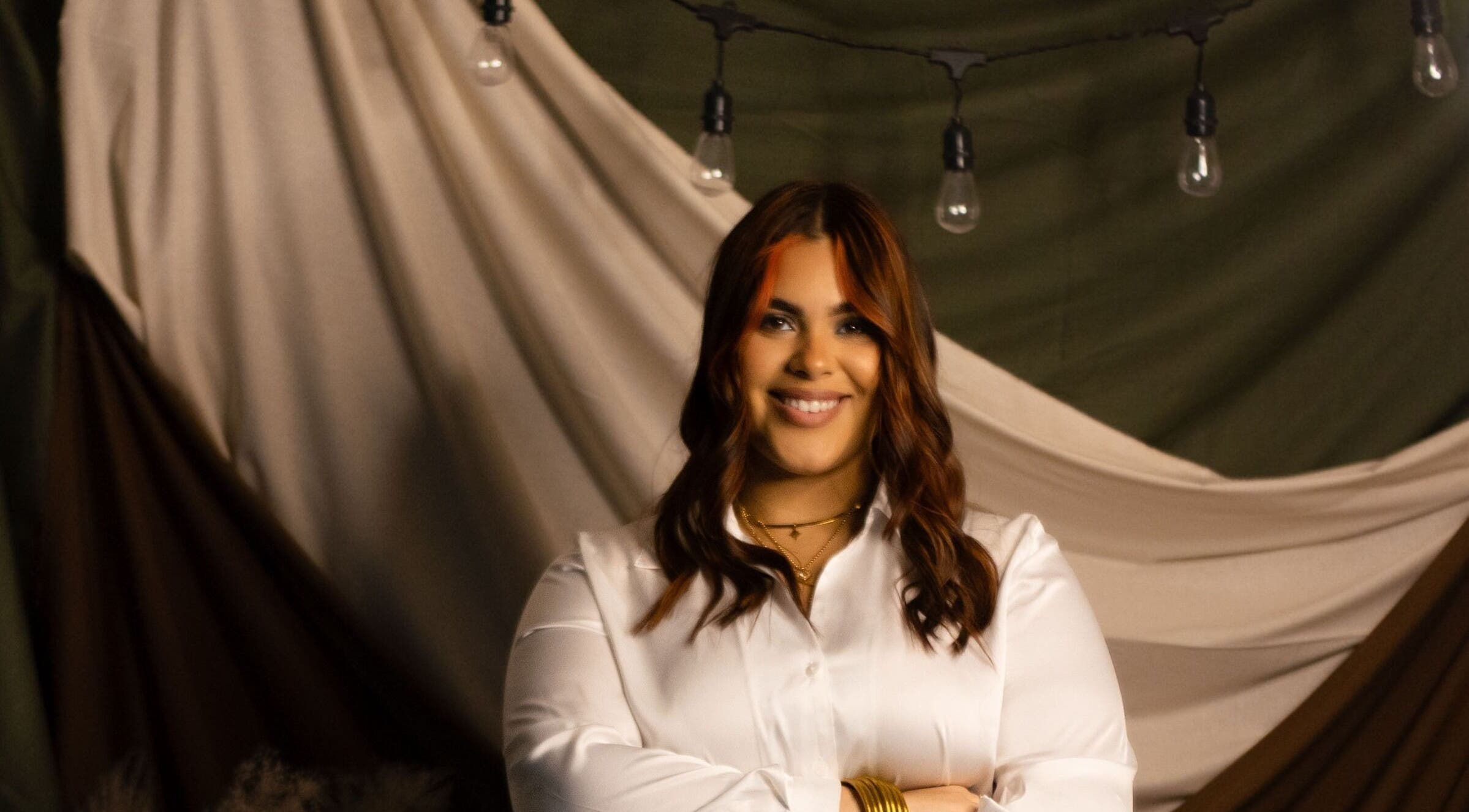 Smiling person at JULIANA ALAGO | MARBELLA STUDIO, Arecibo, Puerto Rico, PR. Elegant ambiance with string lights.
