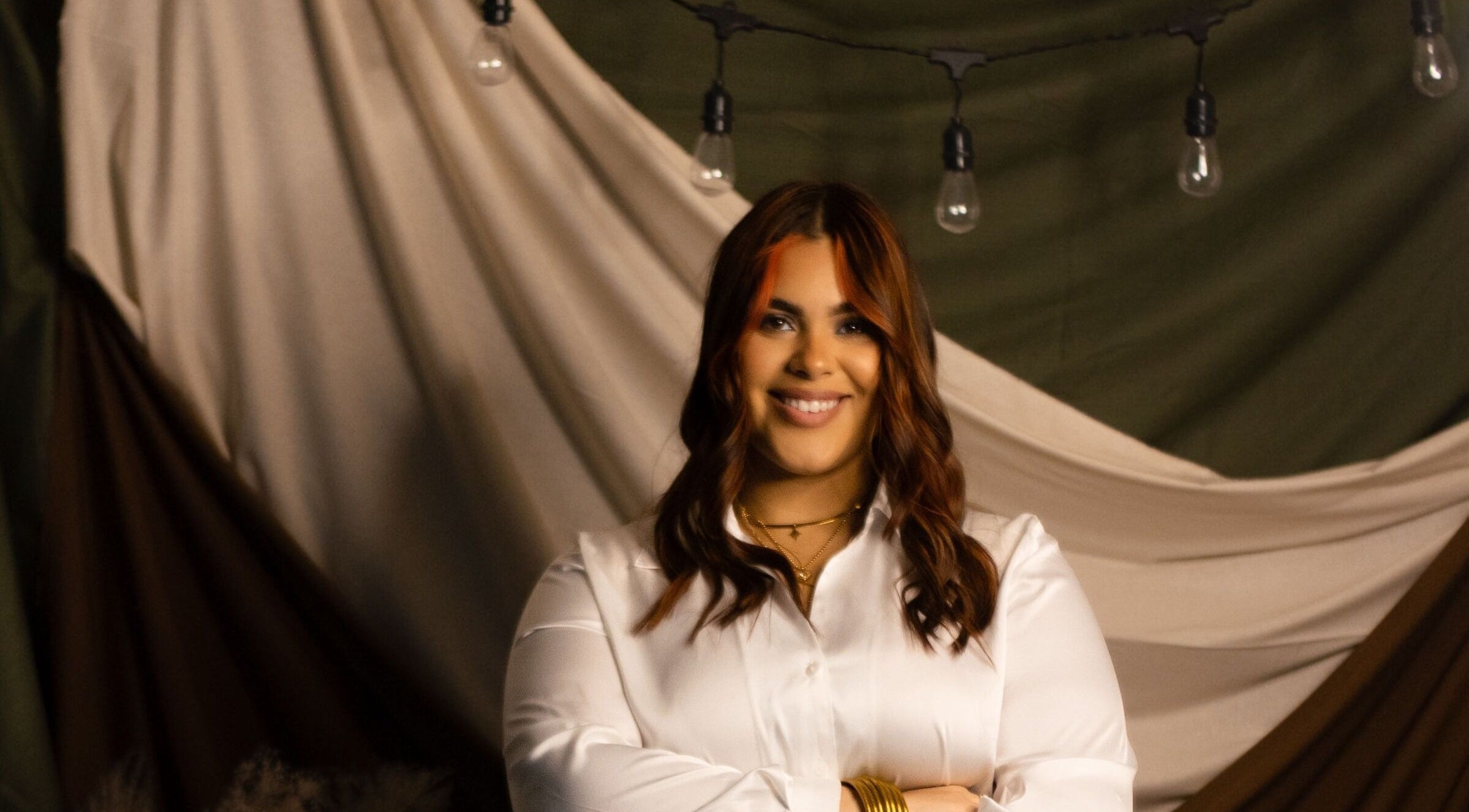 Smiling person at JULIANA ALAGO | MARBELLA STUDIO, Arecibo, Puerto Rico, PR. Elegant ambiance with string lights.