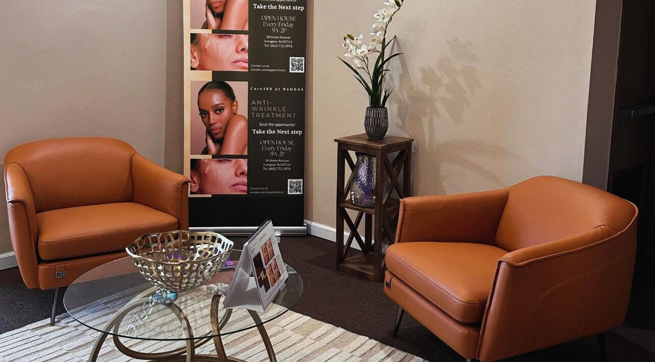 Elegant lounge area at Care360 Aesthetics and Wellness, Lagos, NG with plush chairs and a stylish decor display.