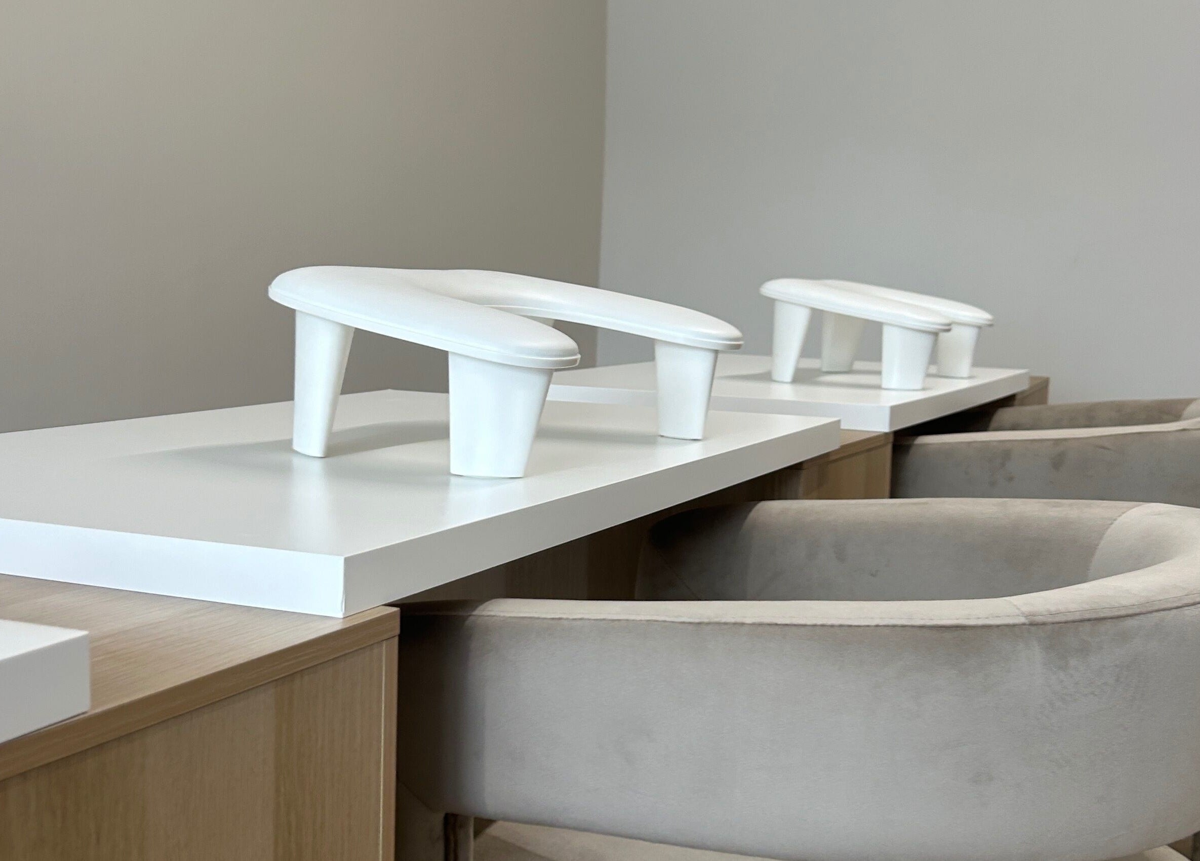 Modern manicure station at Pura Vida Salon, Plymouth, England, GB. Featuring sleek white accents and plush seating.