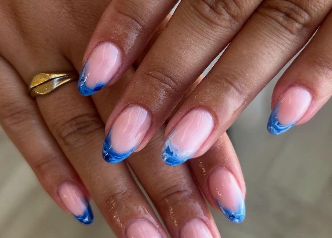 Elegant blue-tipped nails at Pura Vida Salon, Plymouth, England, GB showcase creative nail art.