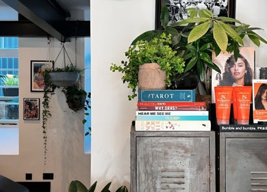 Craft Hairdressing Tring, England: Stylish salon interior with greenery, books, and beauty products displayed.