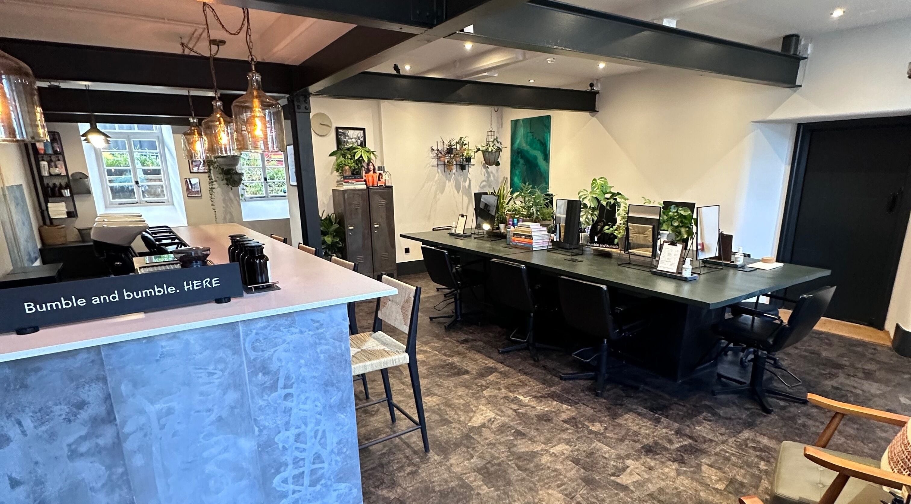 Modern interior of Craft Hairdressing in Tring, England, GB with sleek design and vibrant plants.