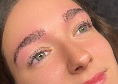 Sourcils impeccables réalisés chez Enchanté Beautee, Laval, Québec, CA, mettant en valeur des yeux verts.