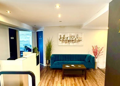 Intérieur accueillant d'Enchanté Beautee à Laval, Québec, CA avec canapé bleu et décor moderne.