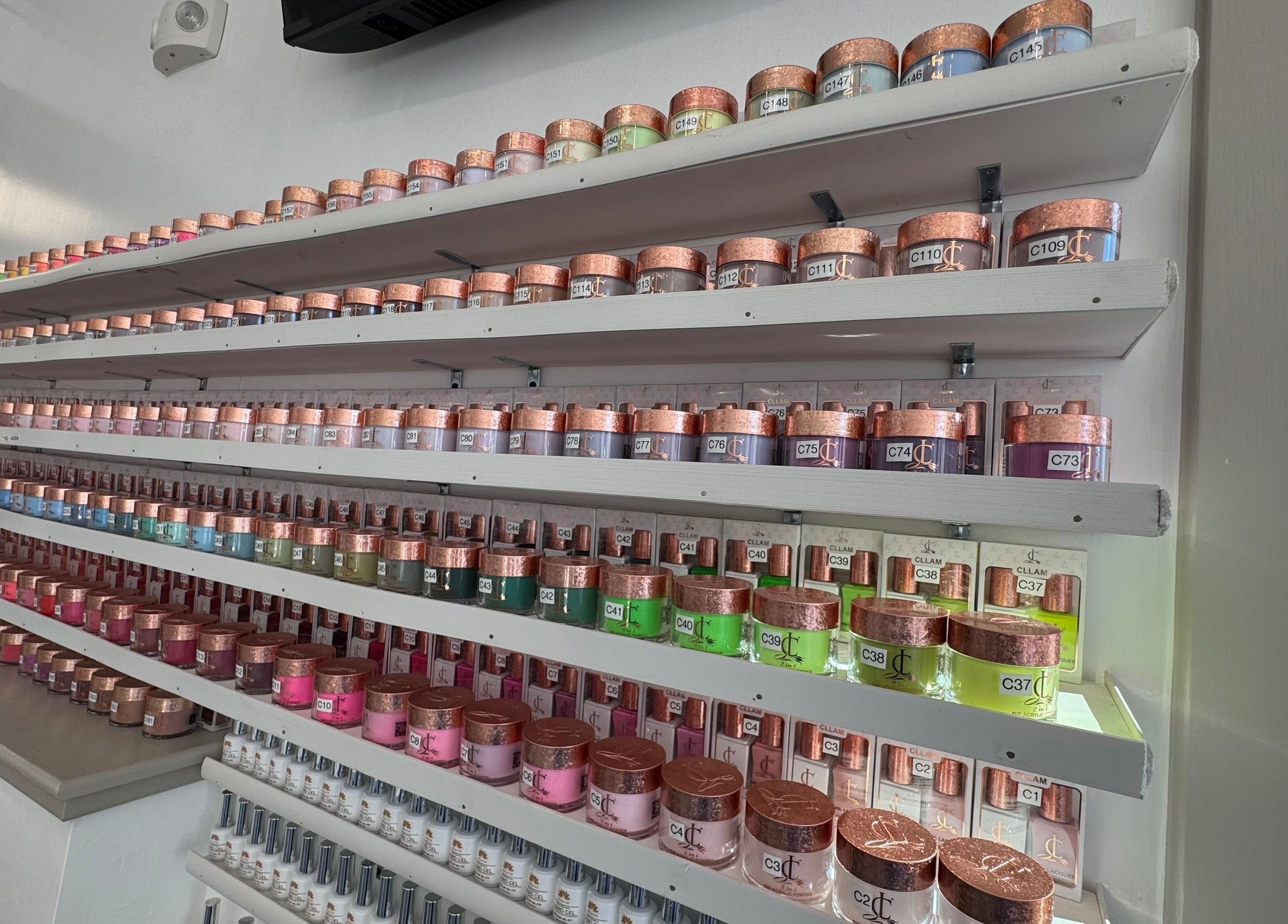Rows of colorful nail jars at D Nails and Spa Dracut, showcasing vibrant options in Dracut, Massachusetts, US.