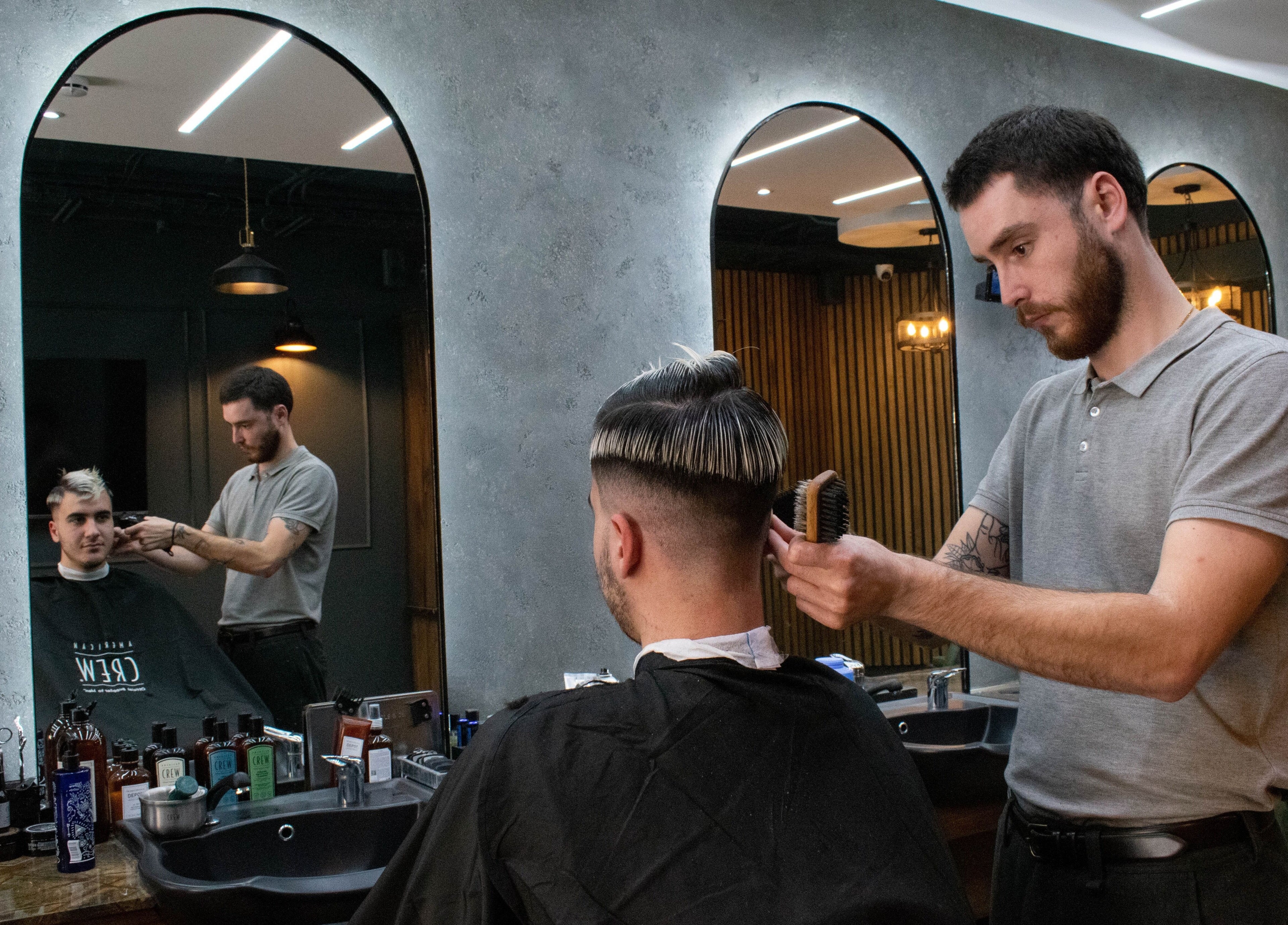 Stylist at il-Mustaċċun Barber in Ħal Lija, MT, expertly crafts a modern haircut.