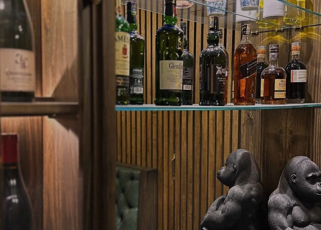 Elegant display of spirits and gorilla statues at il-Mustaċċun Barber, Ħal Lija, MT.