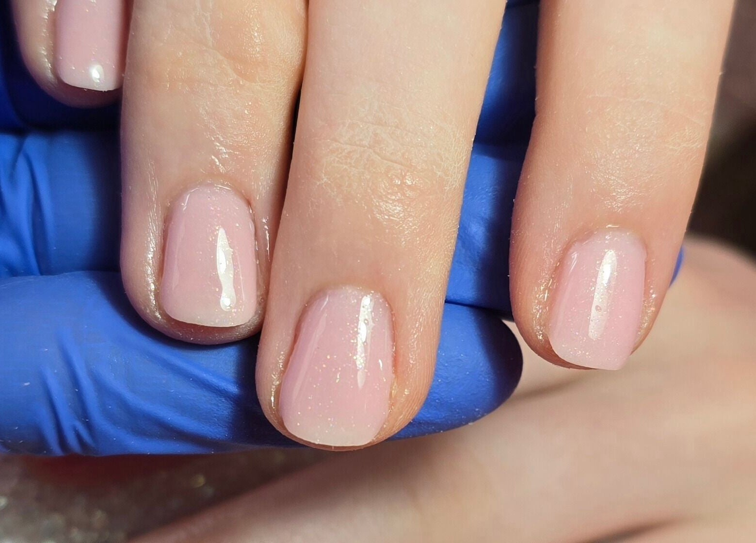 Freshly manicured nails at Nailed It By Laura, Carluke, Scotland, GB, showcasing glossy light pink polish.