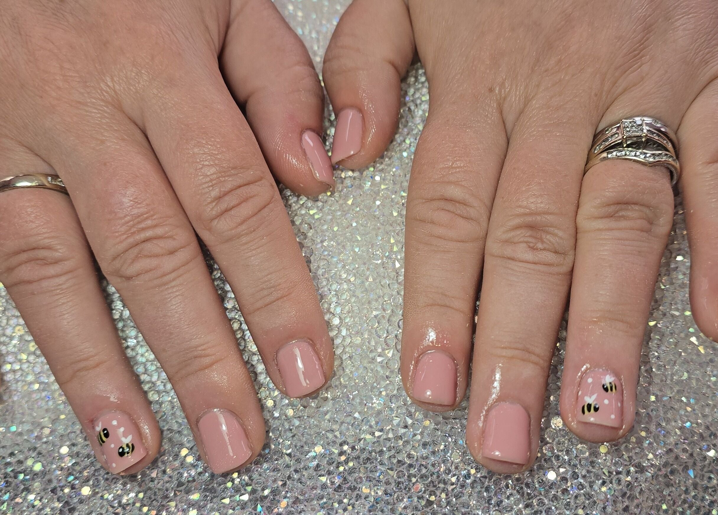 Stylish pink nails with bee designs at Nailed It By Laura, Carluke, Scotland, GB.