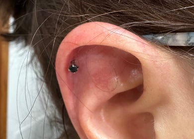 Detailed view of an ear with a piercing stud at Pierced, Tioga, North Dakota, US.