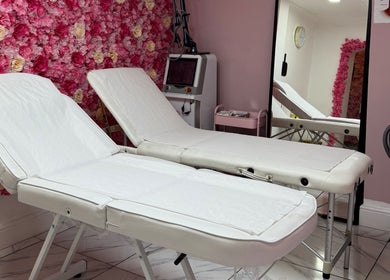 Treatment beds at My Beauty Lounge, London, England, GB, with a pink floral wall backdrop.