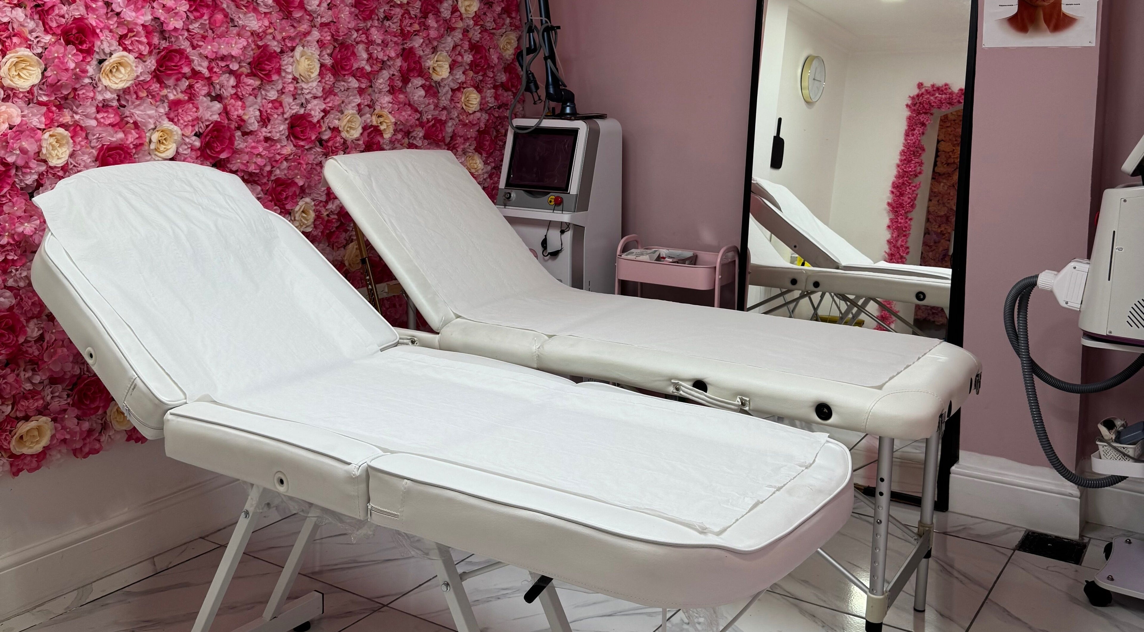 Treatment beds at My Beauty Lounge, London, England, GB, with a pink floral wall backdrop.