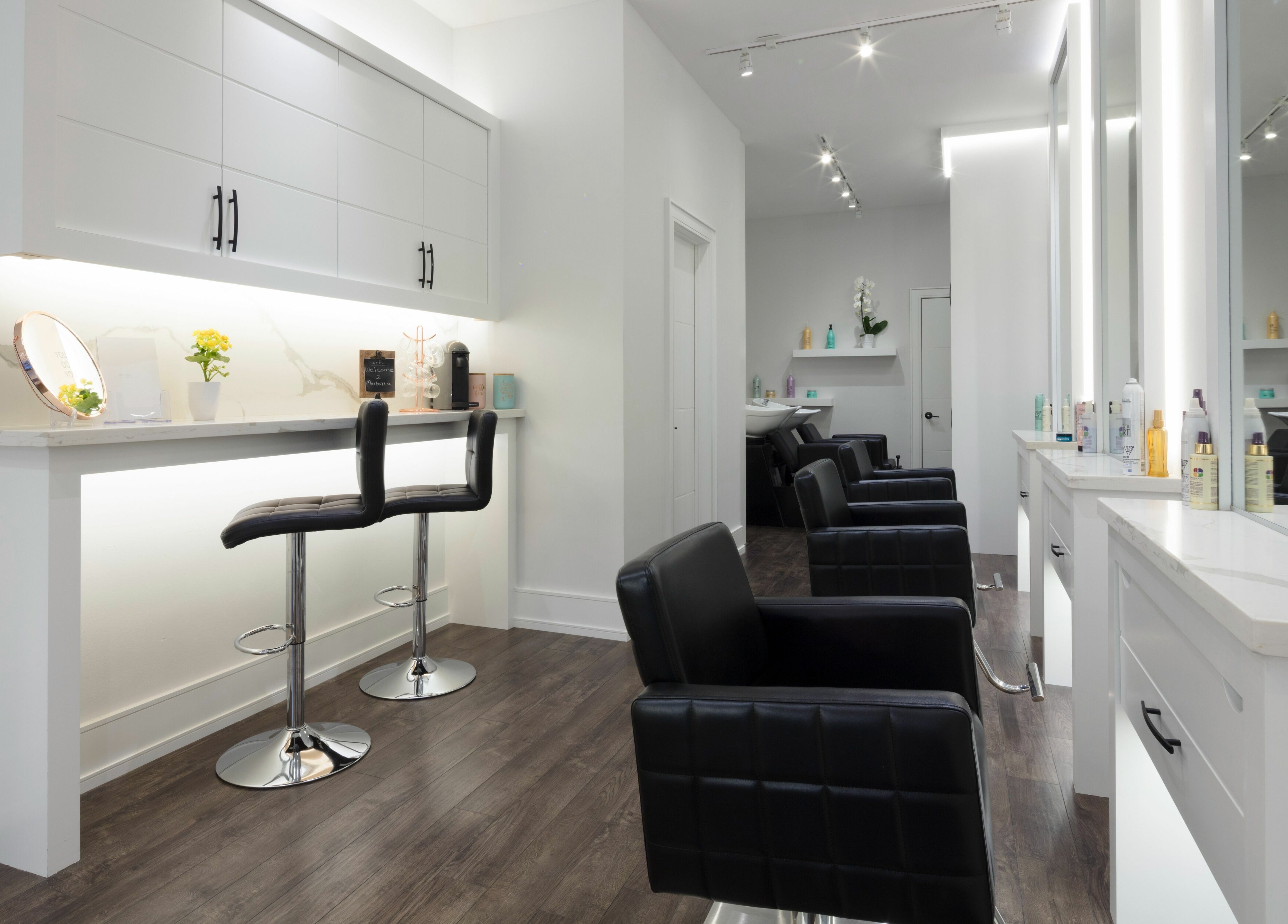 Modern salon interior at Marbella Hair Lab, Toronto, Ontario, CA, features sleek chairs and stylish decor.