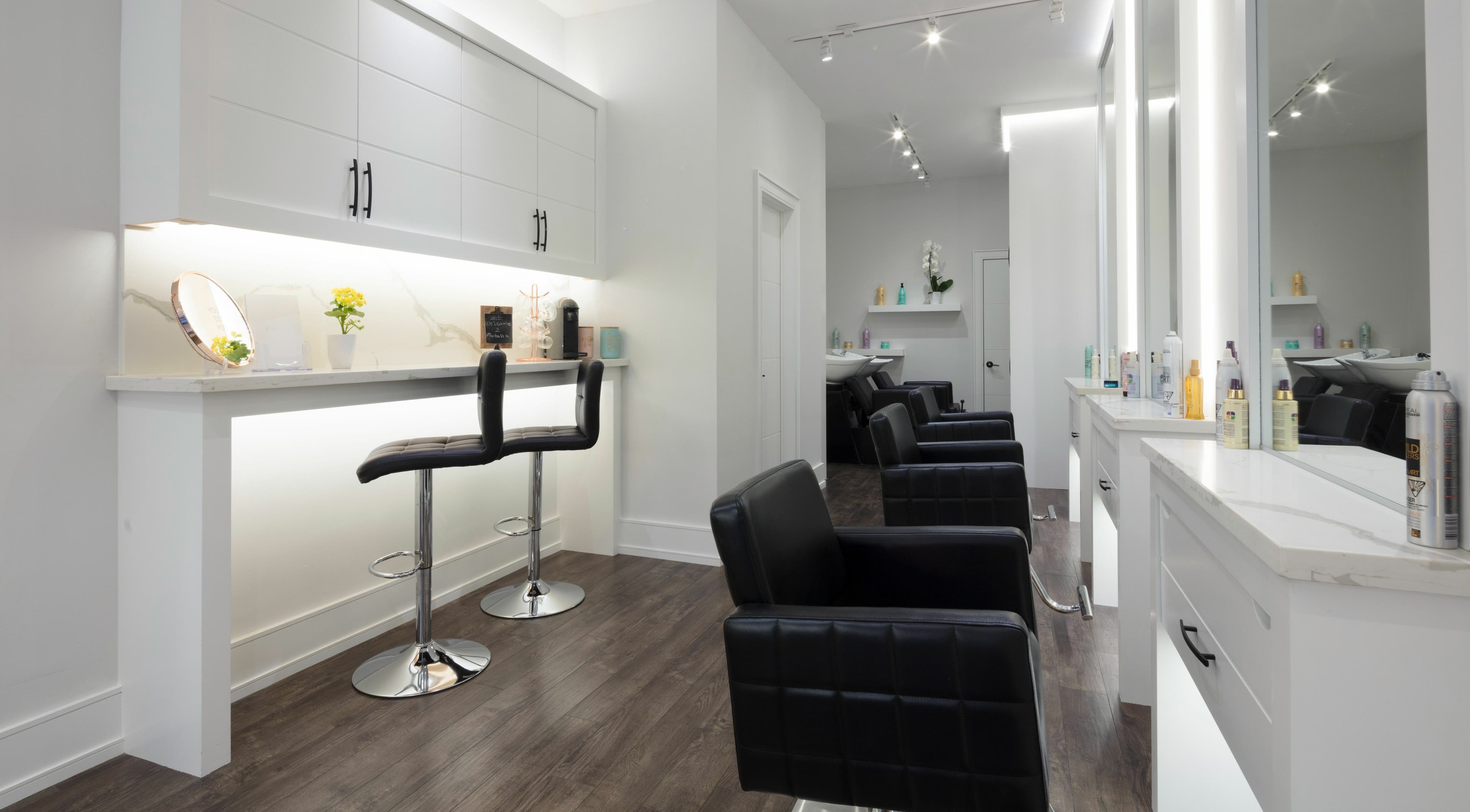 Modern salon interior at Marbella Hair Lab, Toronto, Ontario, CA, features sleek chairs and stylish decor.