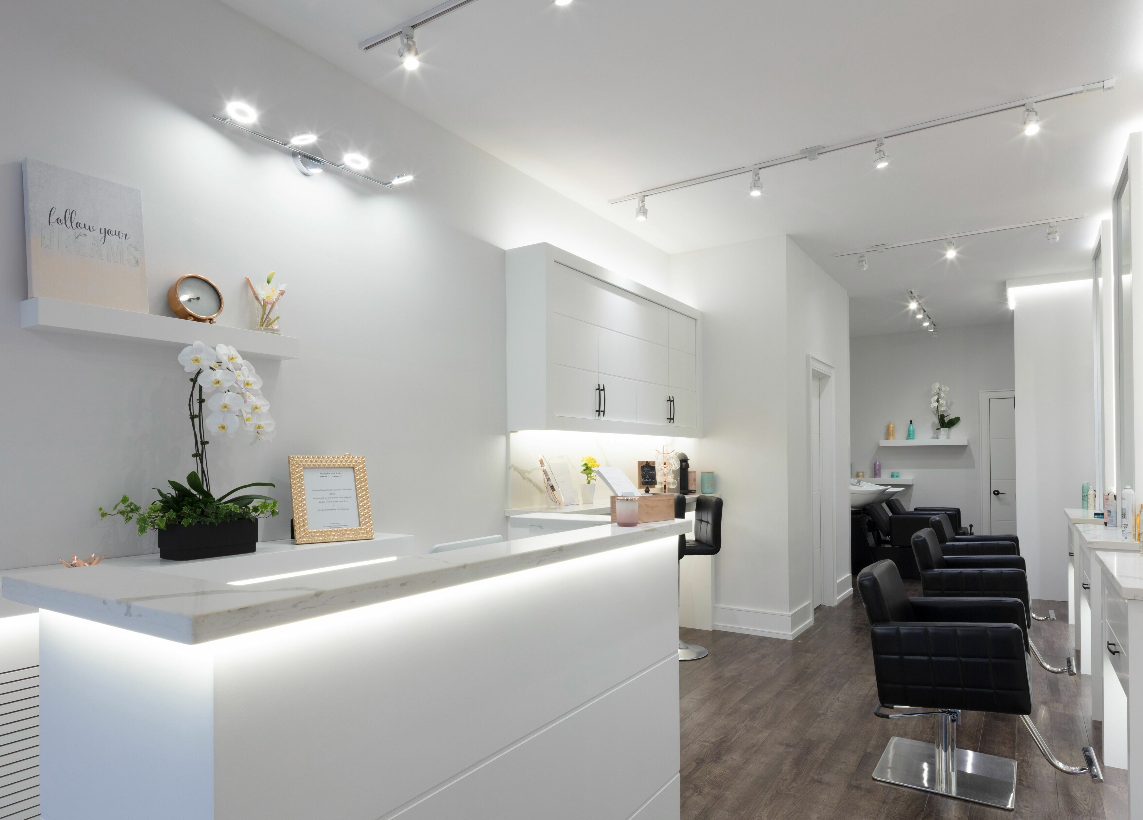 Sleek salon interior at Marbella Hair Lab, Toronto, Ontario, CA, showcasing modern design and luxury seating.