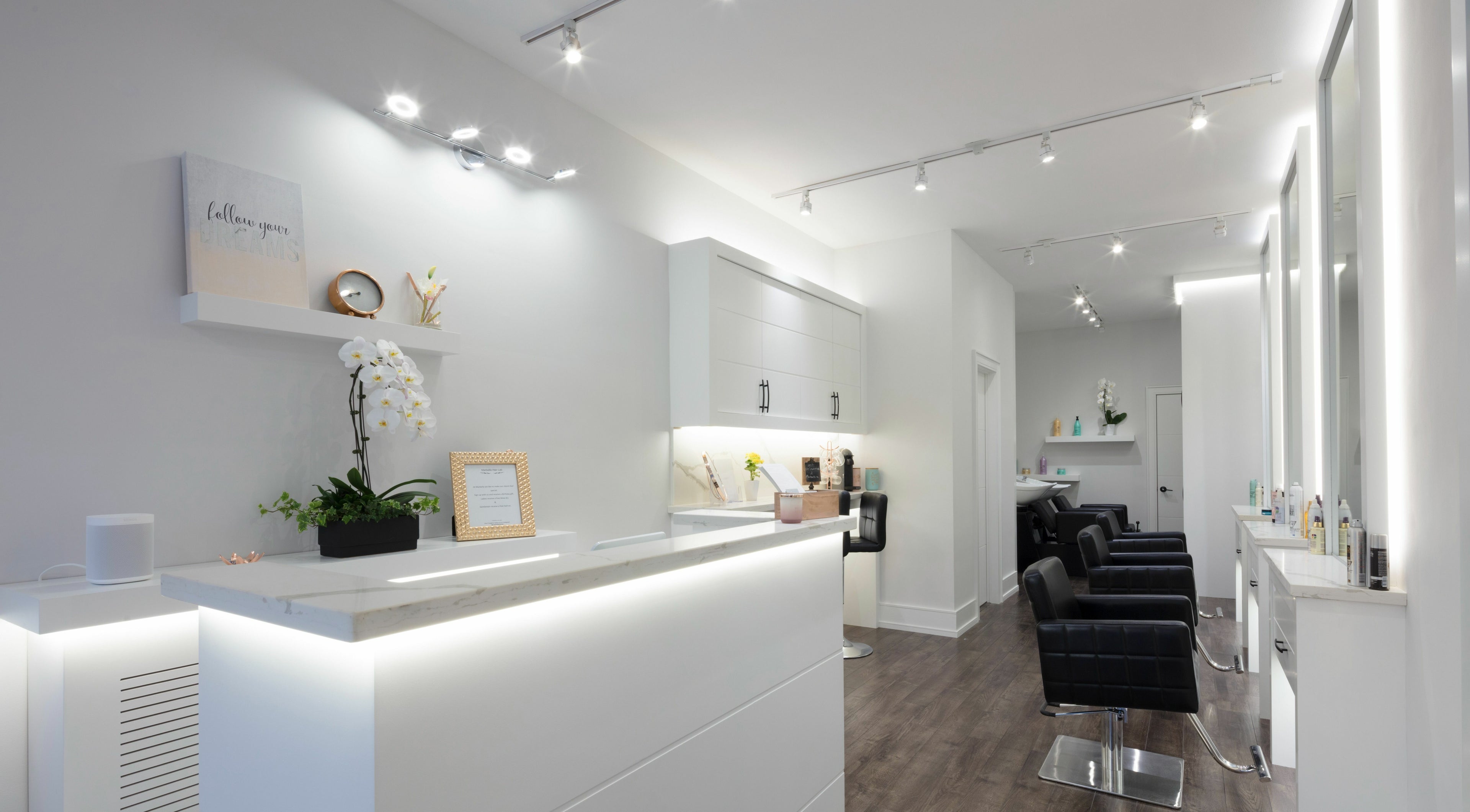 Sleek salon interior at Marbella Hair Lab, Toronto, Ontario, CA, showcasing modern design and luxury seating.