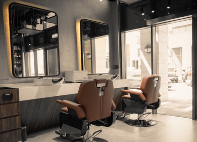 Modern interior of Urban Global Barbershop in Abu Dhabi, AE with stylish barber chairs and large mirrors.