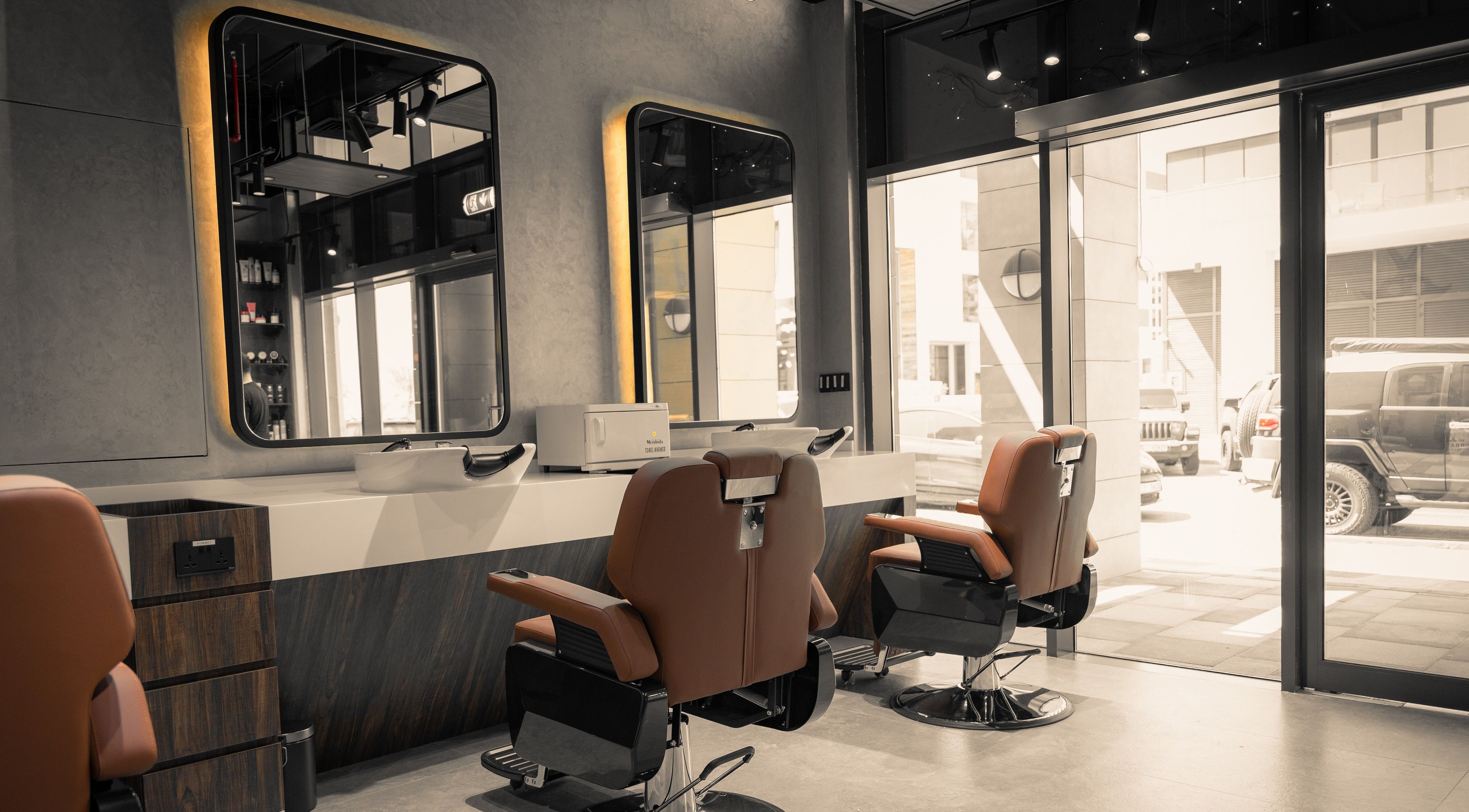Modern interior of Urban Global Barbershop in Abu Dhabi, AE with stylish barber chairs and large mirrors.