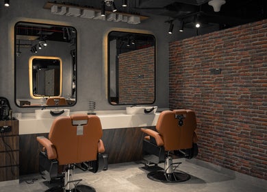 Chic interior of Urban Global Barbershop in Abu Dhabi, AE, featuring modern barber chairs and mirrors.