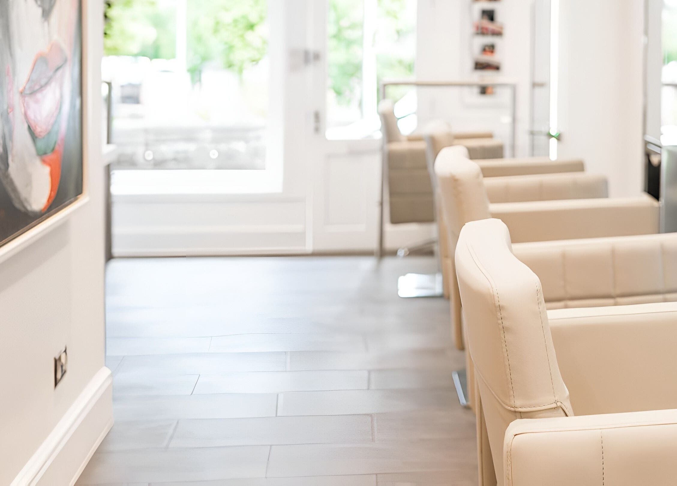 Elegant interior of Salon 32 in Middlewich, England, GB, showcasing modern beige seating and vibrant wall art.