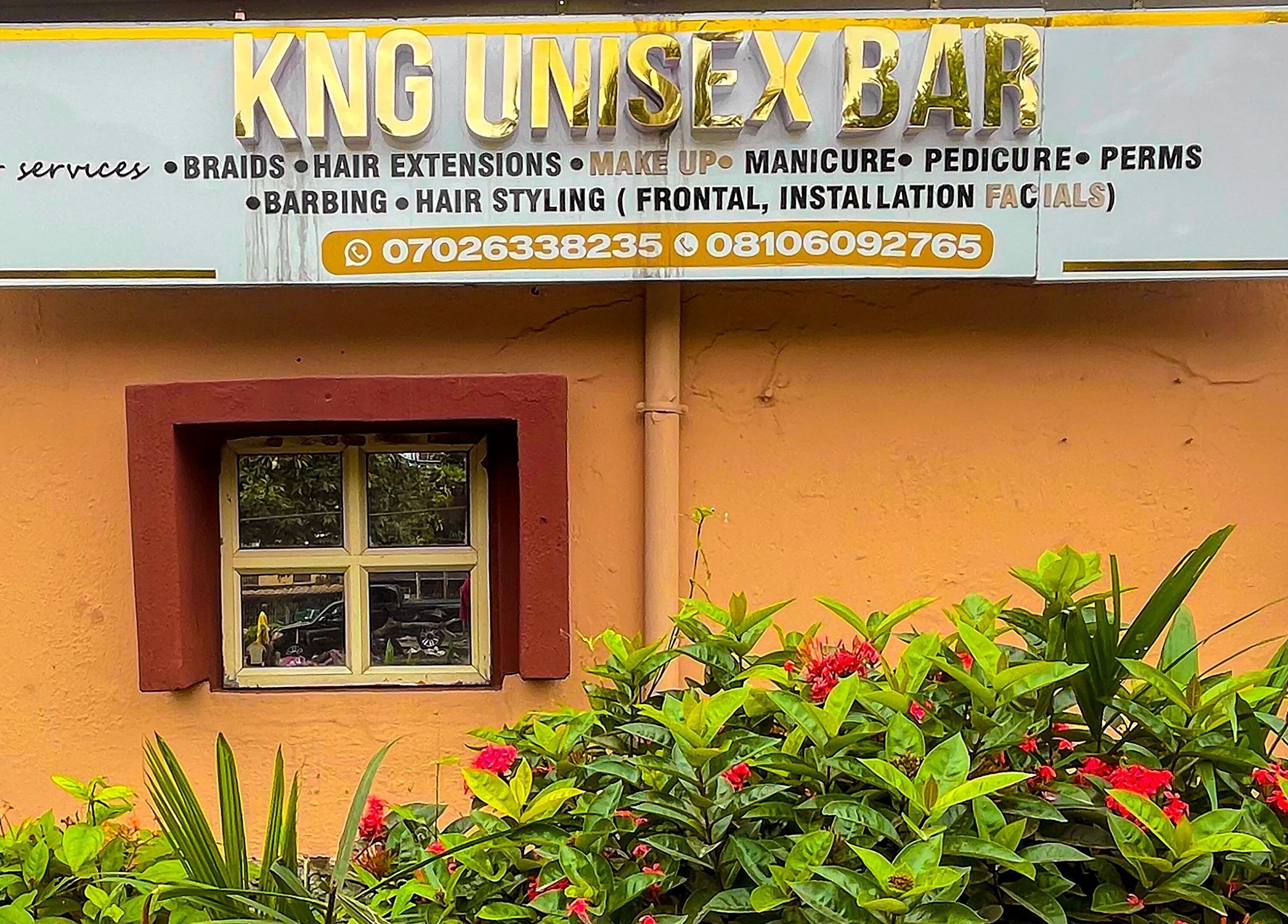 KNG Beauty Bar's welcoming entrance in Lagos, Lagos, NG, showcasing vibrant greenery and a stylish sign.
