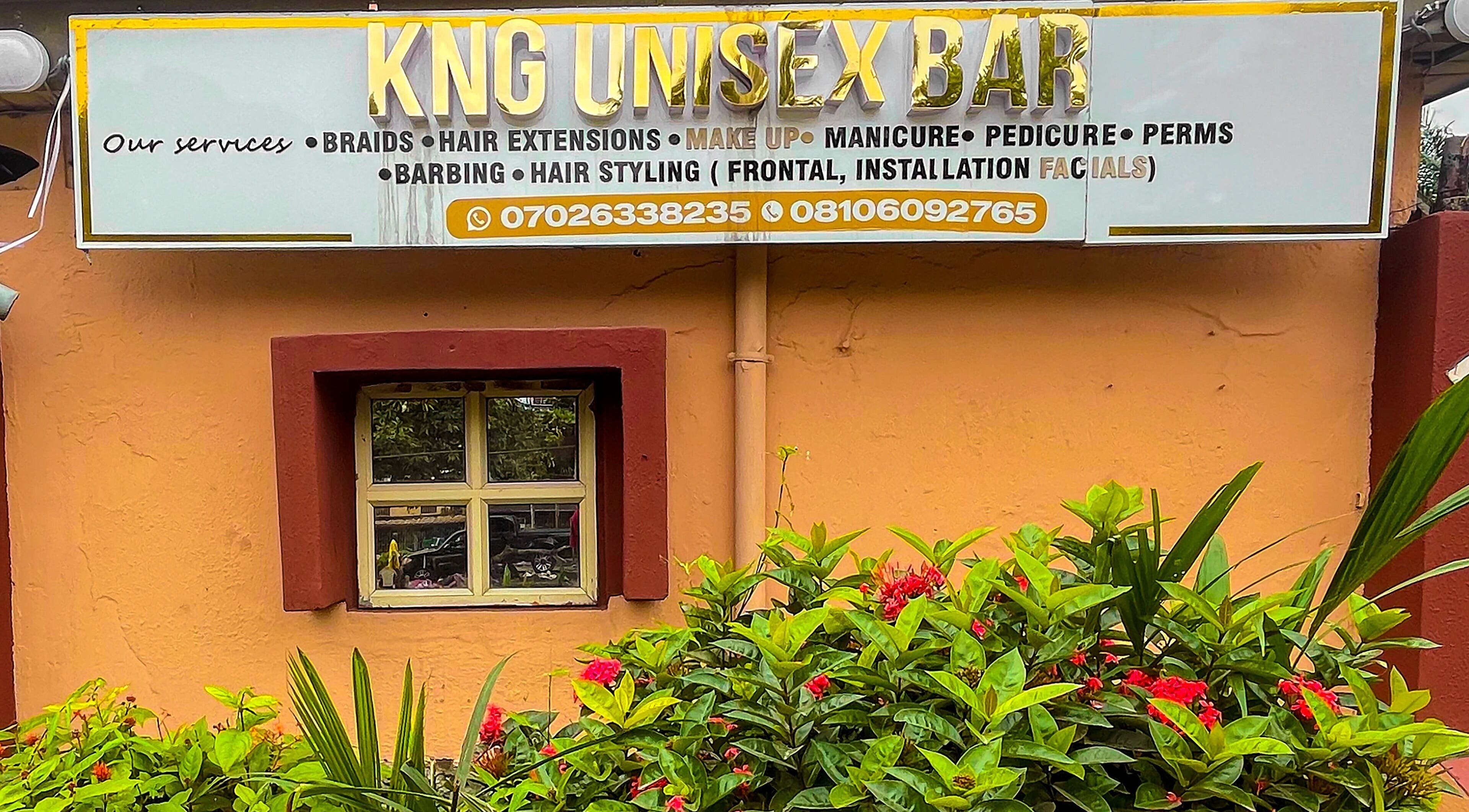 KNG Beauty Bar's welcoming entrance in Lagos, Lagos, NG, showcasing vibrant greenery and a stylish sign.