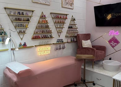 Elegant beauty setup at CuteTique Salon, Kissimmee, Florida, US, featuring a pink chair and product displays.