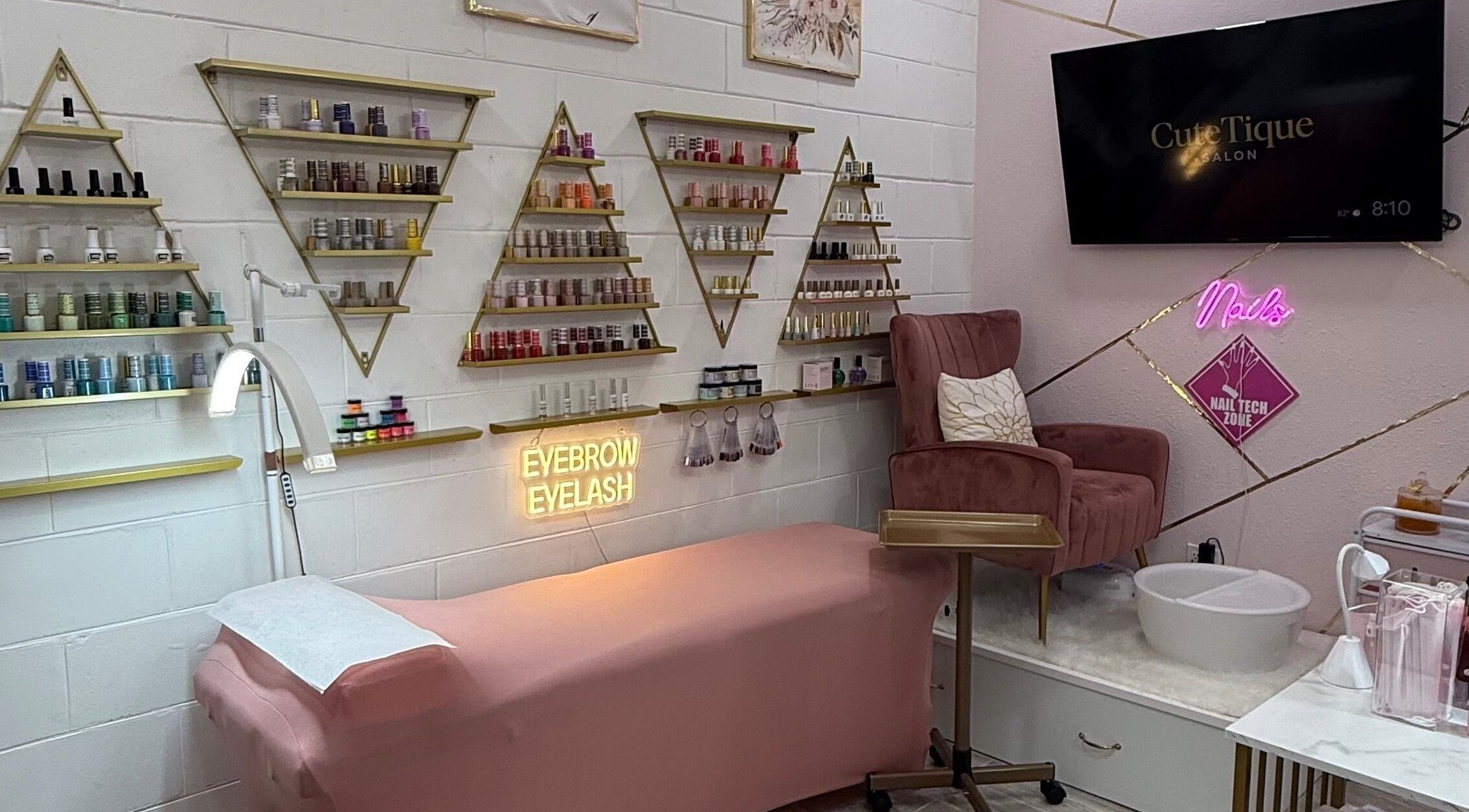 Elegant beauty setup at CuteTique Salon, Kissimmee, Florida, US, featuring a pink chair and product displays.