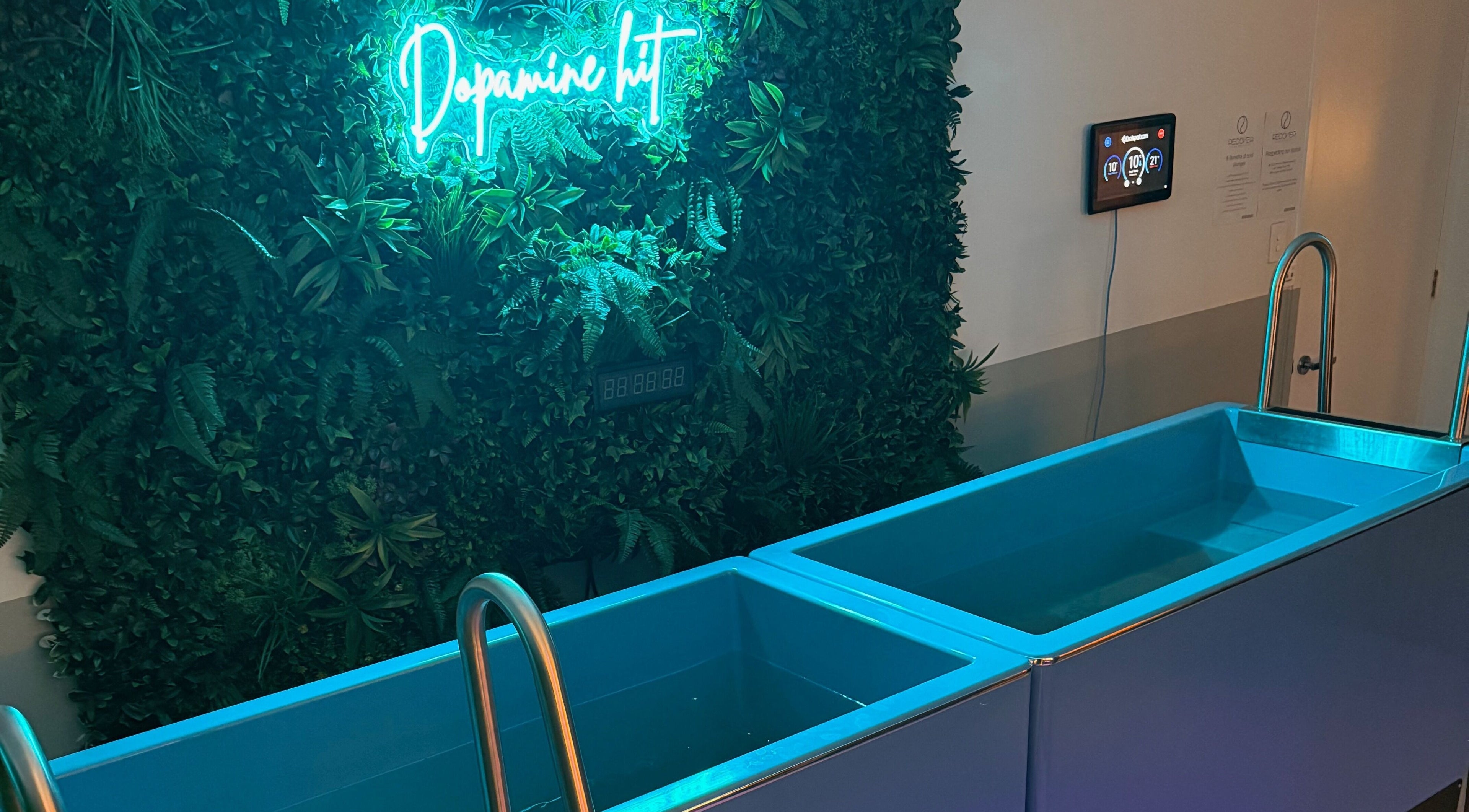 Tranquil spa setting at Recover and Refresh, Grafton, New South Wales, AU, with neon sign and serene water tubs.