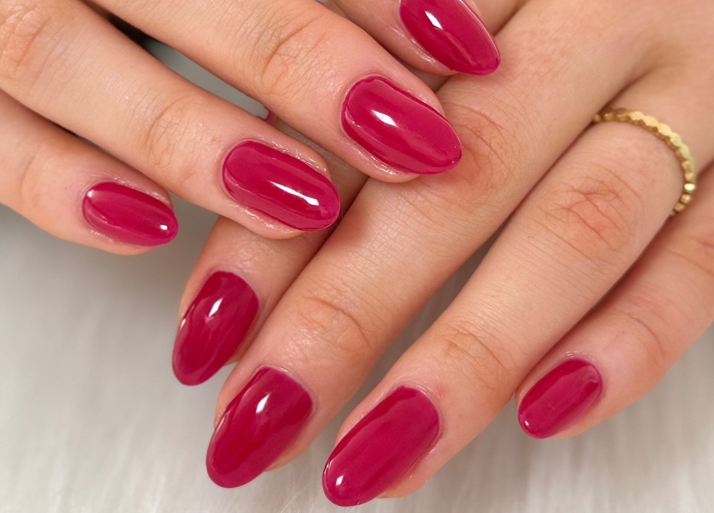 Elegant manicured hands with glossy red polish at Creative Touch by RK, Tauranga, Bay of Plenty, NZ.