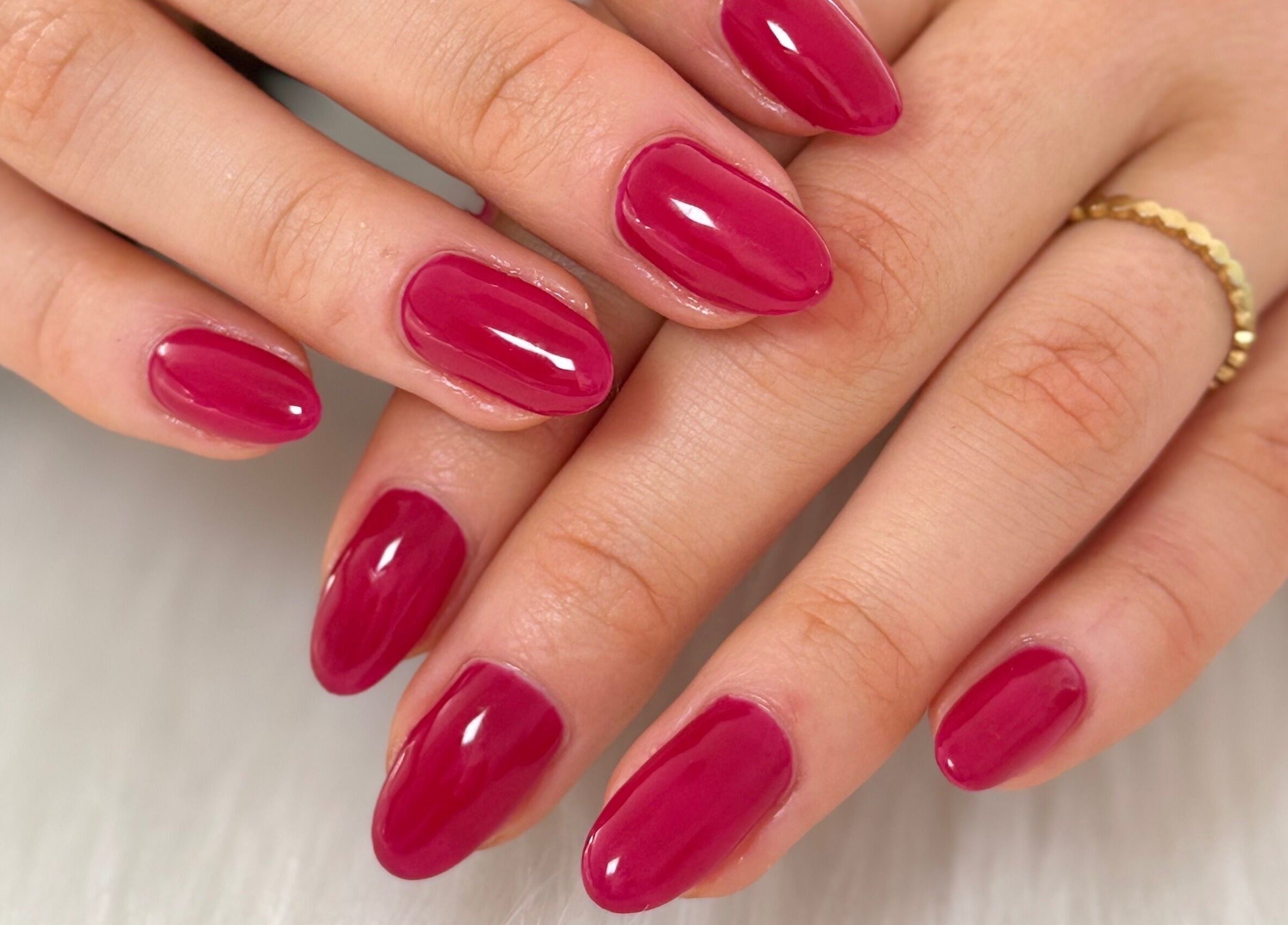 Elegant manicured hands with glossy red polish at Creative Touch by RK, Tauranga, Bay of Plenty, NZ.