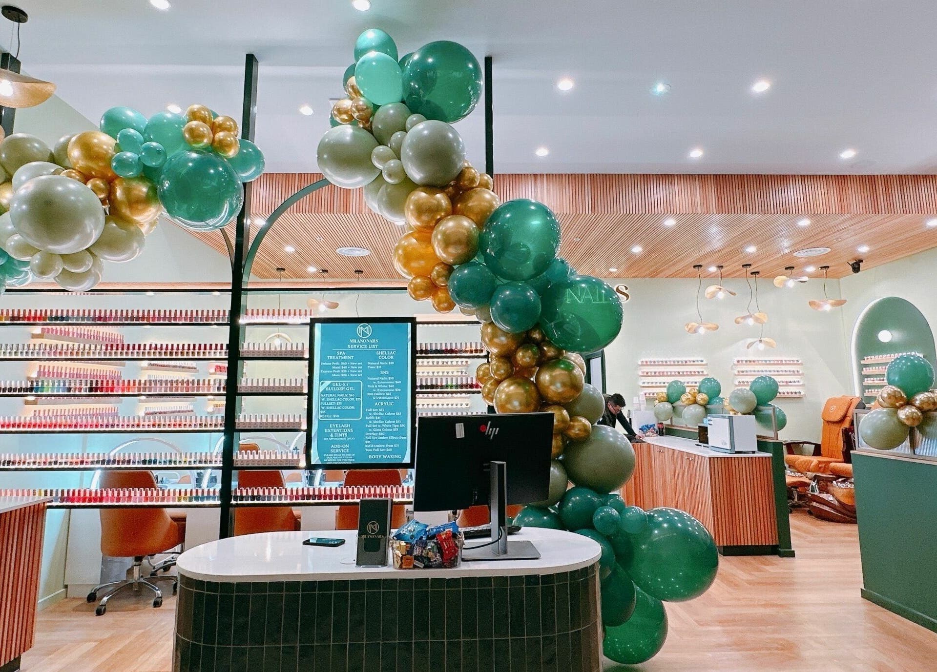 Milano Nails Southland in Melbourne features elegant decor with green and gold balloons, creating a welcoming ambiance.