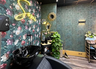 Stylish floral interior at Somi’s Hair and Beauty, Glasgow, Scotland, GB, showcasing washing station and decor.