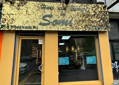 Exterior view of Somi’s Hair and Beauty in Glasgow, Scotland, GB featuring a gold sign above the entrance.