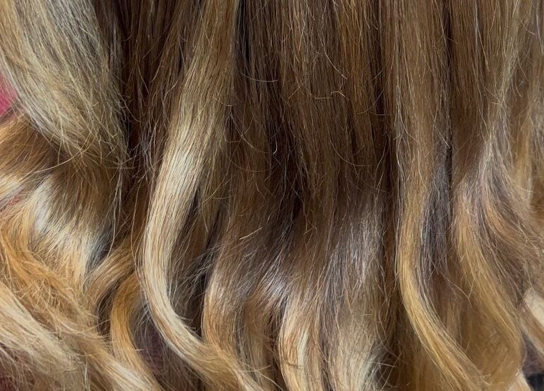 Wavy, golden hair styled at Glam Sanctuary in Stone Mountain, Georgia, US, showcasing elegance and shine.