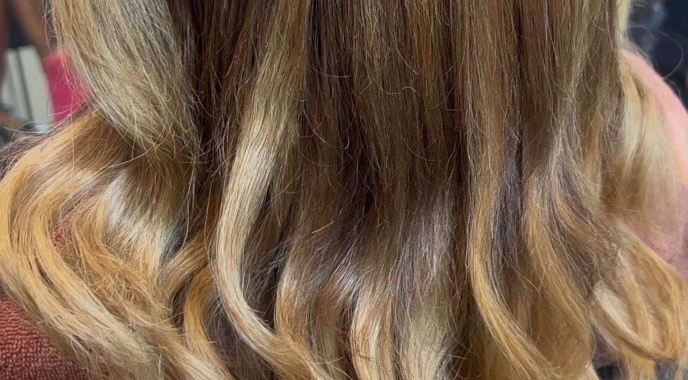 Wavy, golden hair styled at Glam Sanctuary in Stone Mountain, Georgia, US, showcasing elegance and shine.