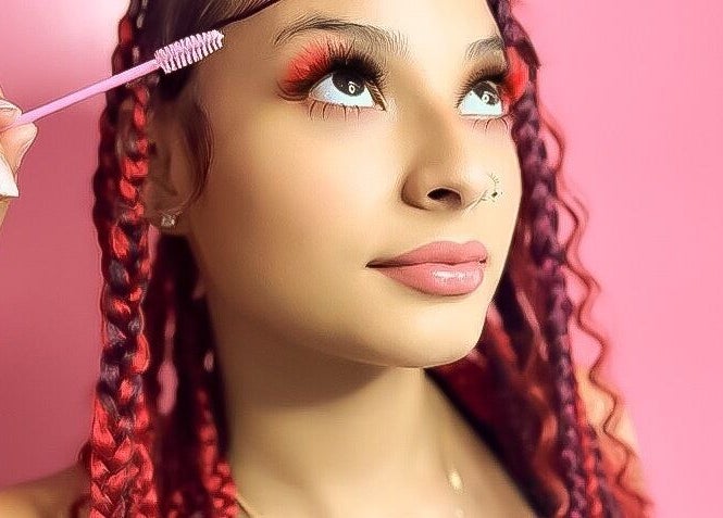 Woman with styled braids and pink makeup at Glam Sanctuary, Stone Mountain, Georgia, US.