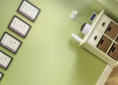 Awards showcased on a green wall at Cherry Tree Beauty, Yaxley, England, GB. Modern ambiance with woven storage.