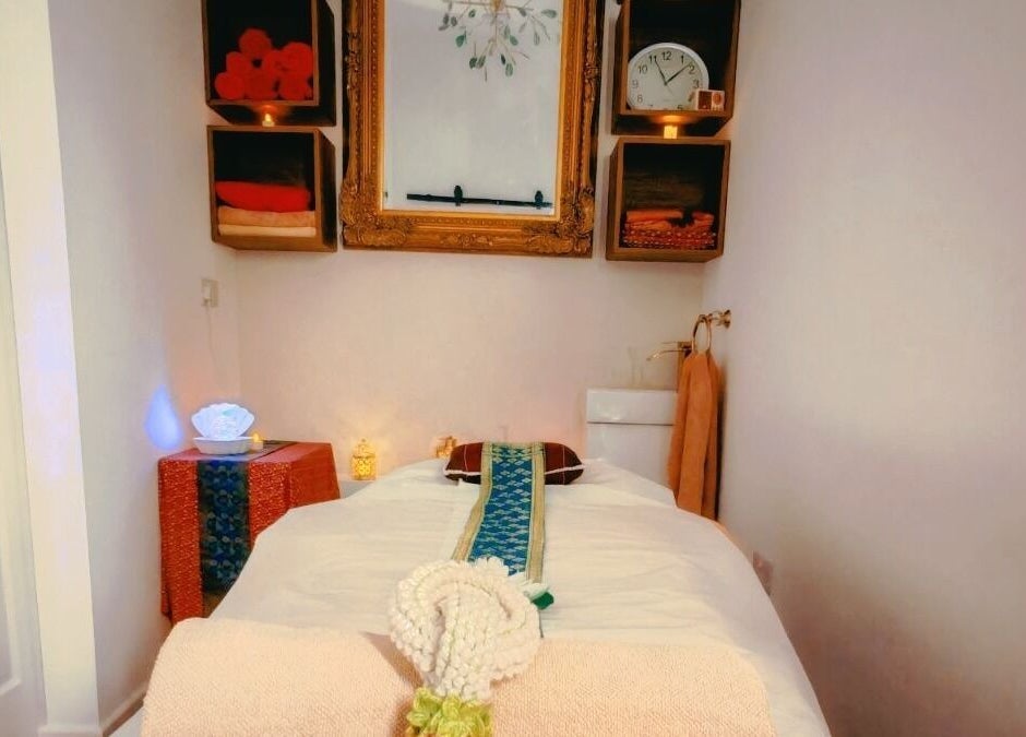 Relaxing massage room at The Andaman Sanctuary, Twickenham, England, GB, featuring warm lighting and a serene ambiance.