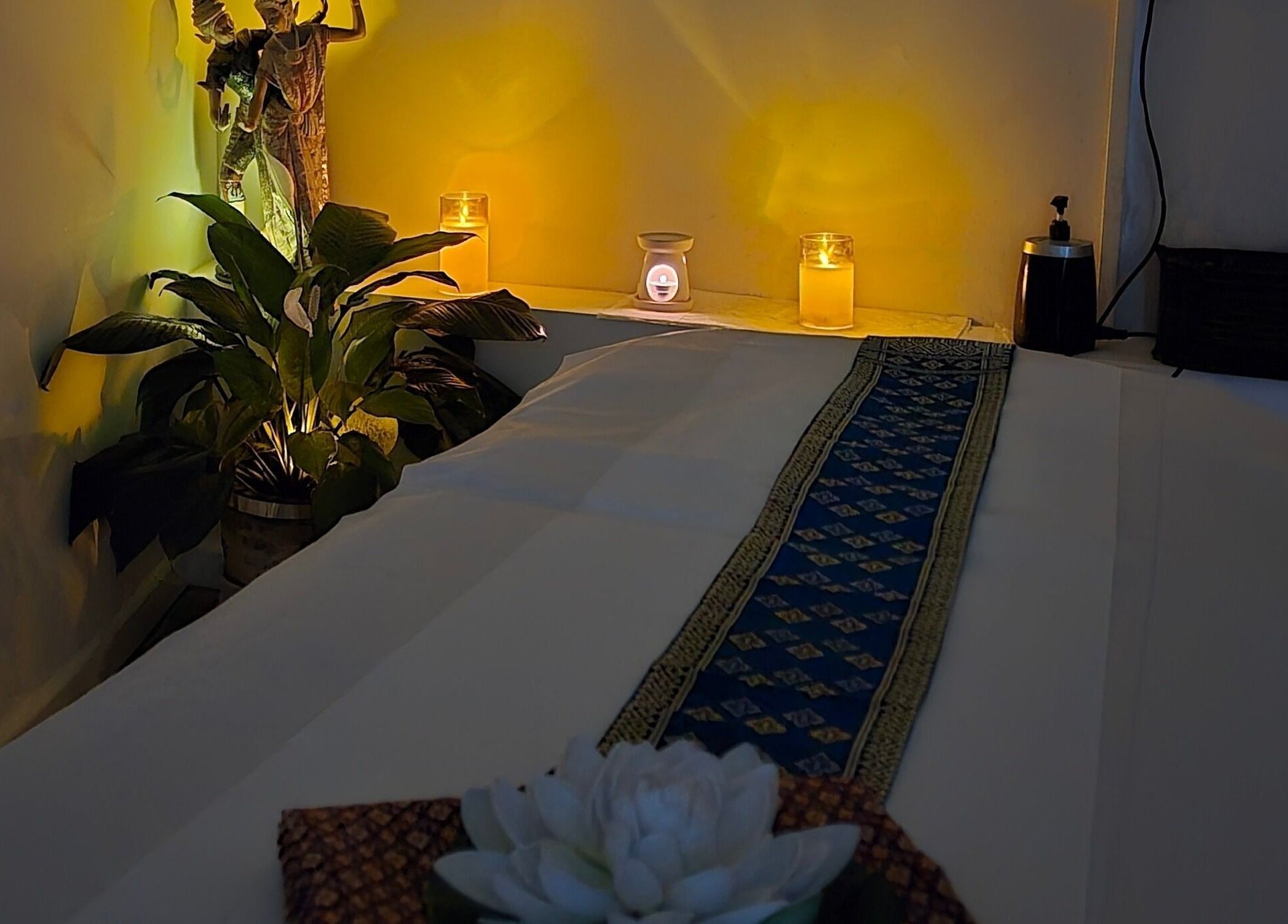 Tranquil massage room at The Andaman Sanctuary, Twickenham, England, GB with candles and plants.