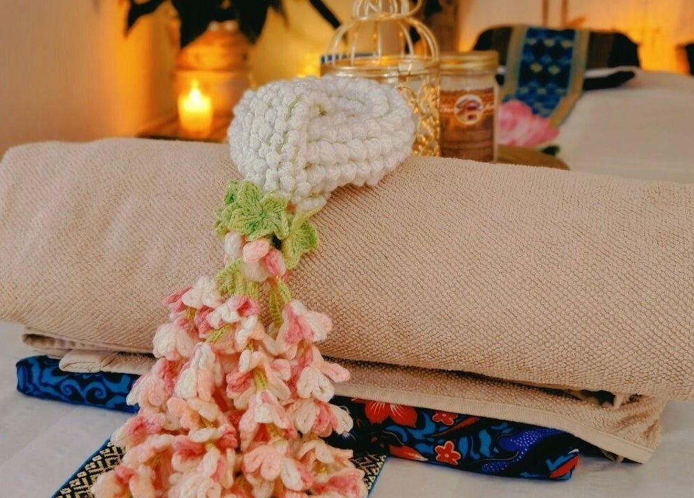 Luxurious massage setup at The Andaman Sanctuary in Twickenham, England, GB, with candles and plush towels.