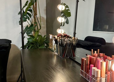 Espaço de maquiagem no Cris Ferraz Beauty em Sydney, New South Wales, AU, com espelho iluminado e pincéis.