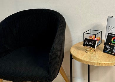 Área de espera acolhedora no Cris Ferraz Beauty em Sydney, New South Wales, AU com poltrona e mesa decorativa.